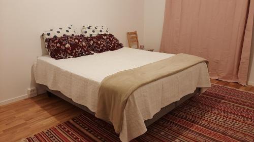 a bedroom with a bed with a blanket and pillows at Stockholm Private Rooms in Shared Lovely, Amazing, Modern Apartment +Garden +BBQ in Stockholm