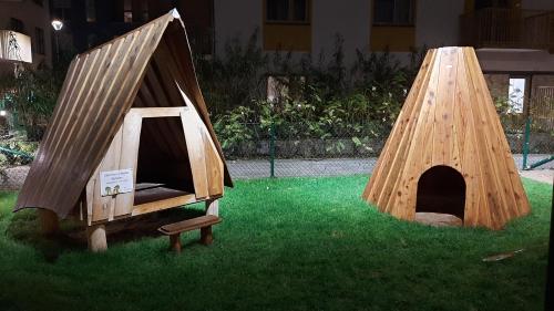 two wooden play tents sitting on the grass at Stockholm Private Rooms in Shared Lovely, Amazing, Modern Apartment +Garden +BBQ in Stockholm