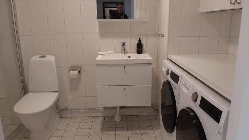 a white bathroom with a toilet and a sink at Stockholm Private Rooms in Shared Lovely, Amazing, Modern Apartment +Garden +BBQ in Stockholm