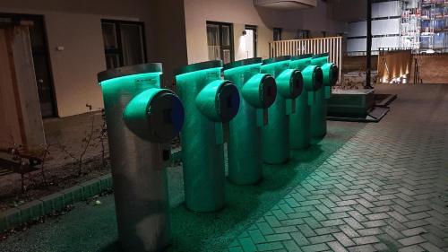 a row of green parking meters on a street at Stockholm Private Rooms in Shared Lovely, Amazing, Modern Apartment +Garden +BBQ in Stockholm