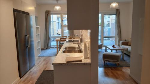 a kitchen with a sink and a living room at Stockholm Private Rooms in Shared Lovely, Amazing, Modern Apartment +Garden +BBQ in Stockholm