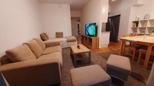 a living room with a couch and a tv and a table at Stockholm Private Rooms in Shared Lovely, Amazing, Modern Apartment +Garden +BBQ in Stockholm