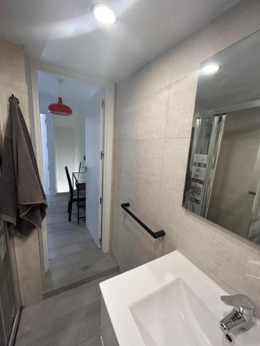 a white bathroom with a sink and a mirror at Casa rústica en Madrid recién reformada in Madrid