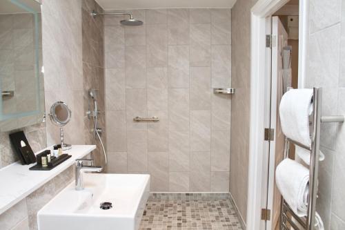 ein Bad mit einem Waschbecken und einer Dusche in der Unterkunft The Fig Tree Hotel in Shanklin