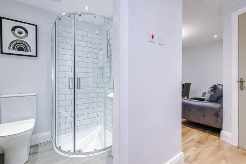 a bathroom with a toilet and a glass shower at Stunning Designer House with Parking Sleeps 8 by PureStay Short Lets & Serviced Accommodation Liverpool in Litherland