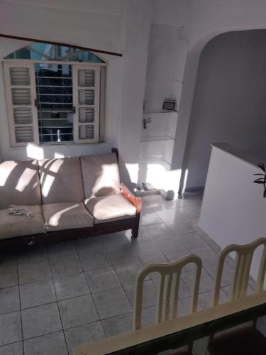 uma sala de estar com um sofá e uma janela em Kitnet temporada Cabo Frio em Cabo Frio