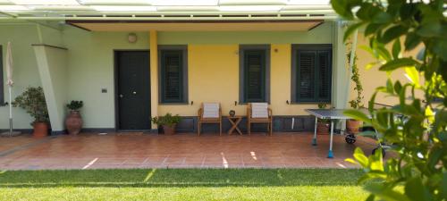 eine Terrasse mit 2 Stühlen und einem Tisch vor einem Haus in der Unterkunft Villa Capogrecale in Piedimonte Etneo