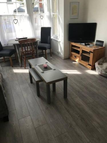 a living room with a table and a flat screen tv at Contractors hub- Families - City Centre - Everhome ltd by Luxiety Stays Short Stay Serviced Accommodation Southend On Sea in Southend-on-Sea