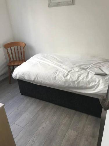 a bed in a bedroom with a wooden floor and a chair at Contractors hub- Families - City Centre - Everhome ltd by Luxiety Stays Short Stay Serviced Accommodation Southend On Sea in Southend-on-Sea