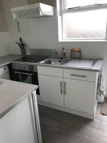 cocina blanca con fregadero y ventana en Contractors hub- Families - City Centre - Everhome ltd by Luxiety Stays Short Stay Serviced Accommodation Southend On Sea, en Southend-on-Sea