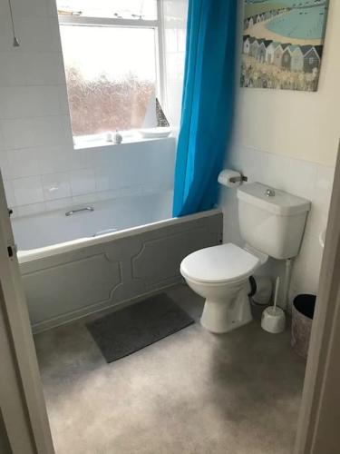a bathroom with a toilet and a tub and a window at Contractors hub- Families - City Centre - Everhome ltd by Luxiety Stays Short Stay Serviced Accommodation Southend On Sea in Southend-on-Sea