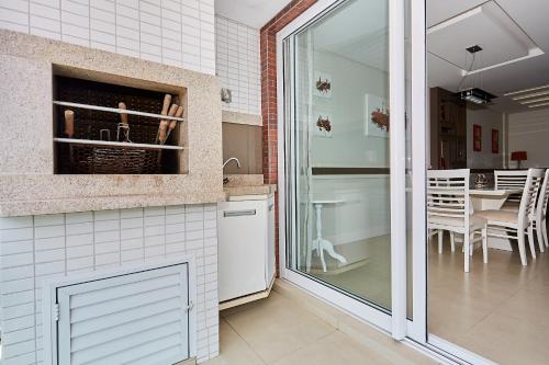 una cocina con una puerta que conduce a un comedor en 1021 Apartamento em condomínio com piscina localizado na Avenida da praia do centro de Bombinhas, en Bombinhas