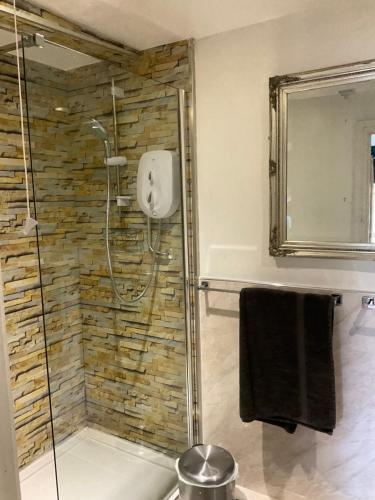 y baño con ducha y pared de piedra. en The Whitehouse Ross-On-Wye, en Ross-on-Wye