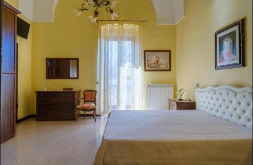 a bedroom with a bed and a dresser and a window at B&B Palazzo Simone in Nardò