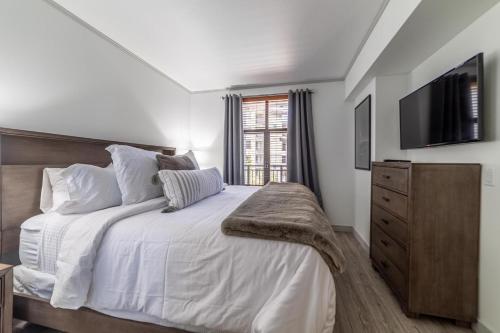 a bedroom with a large bed with a television on the wall at #501-Pet Friendly, 1 Bedroom, Remodeled Village Monache Condo in Mammoth Lakes