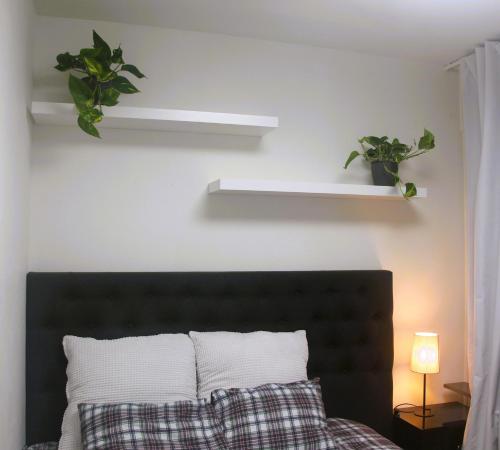 a bedroom with a bed with two plants on the wall at Fully furnished room for rent in Märsta in Märsta