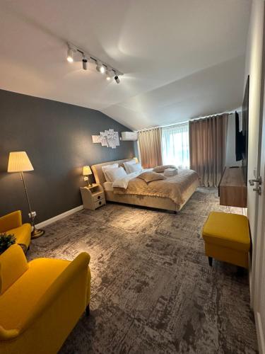 a bedroom with a large bed and a yellow couch at Complex Rediu 54 Luxury Apartaments in Iaşi