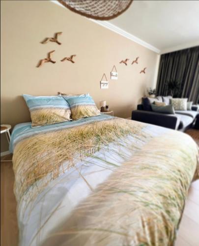 a bedroom with a bed with birds on the wall at Studio Sea View - Royal Ascot in Ostend