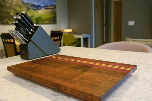 a wooden cutting board sitting on top of a table at Bright Modern Stylish Condo in heart of Downtown (Center) in Whitehorse