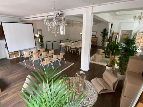 a room with a table and chairs and a projection screen at Superschönes Studio LUNCA 220qm in Stuttgart West in Stuttgart