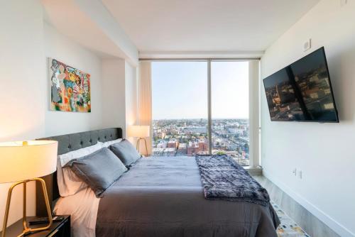 a bedroom with a bed and a large window at 2BR Lux Highrise Hollywood in Los Angeles