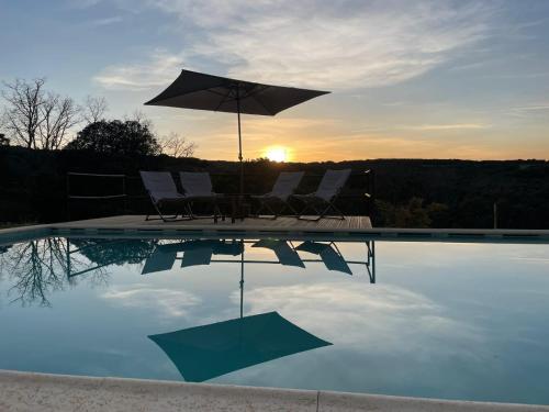 ein Pool mit Stühlen und einem Sonnenschirm und der Sonnenuntergang in der Unterkunft Quinta da Devesa -B2 in Vinhais
