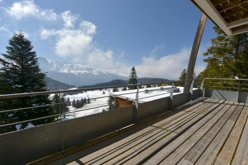 a balcony with a view of a snow covered mountain at Superbe vue sur plateau arselle in Chamrousse