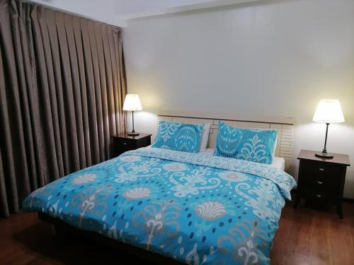 a bedroom with a blue bed with blue pillows at 2 Bedroom Condo in Cebu - opp Ayala in Cebu City