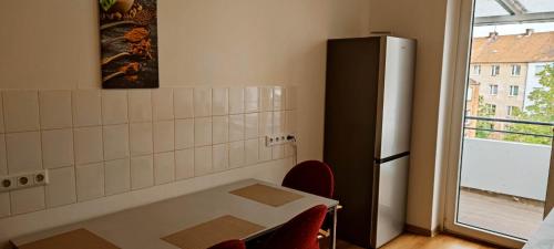 cocina con nevera, mesa y sillas en Othman Appartements Falkenstraße 26 en Hannover