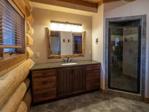 uma casa de banho com um lavatório, um espelho e um chuveiro em Upper Ranch em Granby