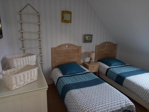 Un dormitorio con 2 camas y una silla. en Sous les toits de Saint-Enogat, en Dinard