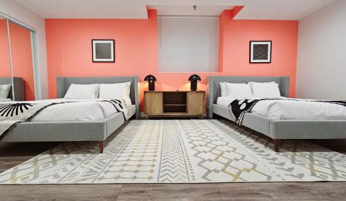 2 letti e un divano in una camera con pareti arancioni di The Lofts on Clematis 204 Downtown West Palm Beach a West Palm Beach
