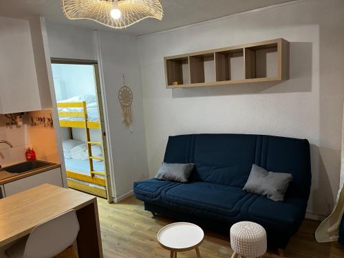 - un salon avec un canapé bleu et une table dans l'établissement Studio Chaleureux au Cap d’Agde, au Cap d'Agde