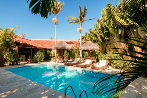 uma piscina num resort com palmeiras em Casa Mar Campeche em Florianópolis