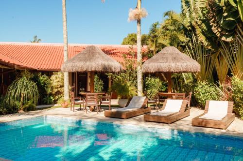 un complejo con una piscina con sillas y sombrillas en Casa Mar Campeche, en Florianópolis