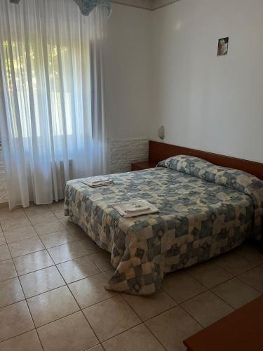 een slaapkamer met een bed met een quilt bij Tenimento Santa Barbara in San Giovanni Rotondo
