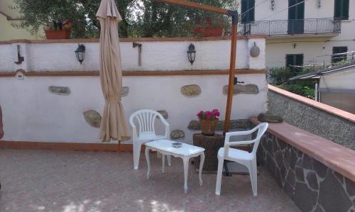 a patio with two chairs and an umbrella at B&B Casa Fei in Signa