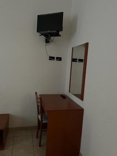 een kamer met een bureau en een televisie aan de muur bij Tenimento Santa Barbara in San Giovanni Rotondo