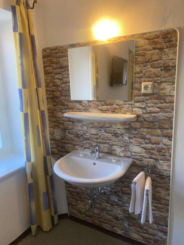 baño con lavabo y pared de piedra en Zimmer 2 am Manötscherhof, en Tires