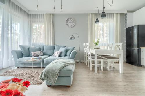 a living room with a blue couch and a table at Apartament Doris 1 z pięknym widokiem in Pobierowo
