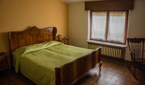 sypialnia z drewnianym łóżkiem i oknem w obiekcie Da zia Maria Casa Vacanze w mieście Monasterolo del Castello