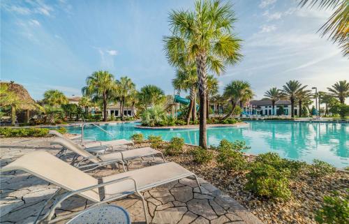 una piscina en un complejo con sillas y palmeras en Champions Gate Resort - 5b4b Villa, en Davenport