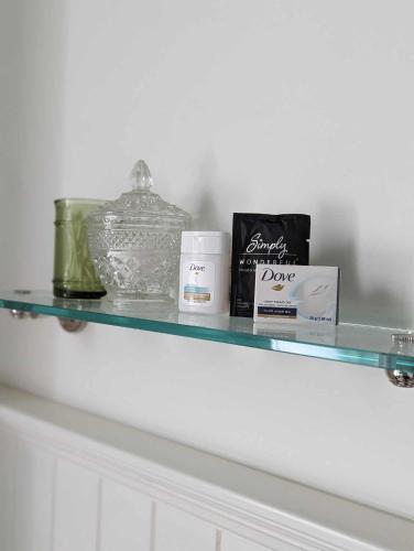 a glass shelf with items on top of a white cabinet at The Vistula Rose B & B in Toledo