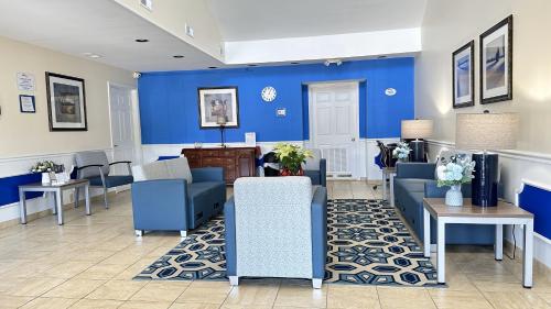 a waiting room with blue walls and blue chairs at Baymont by Wyndham Greenwood in Greenwood