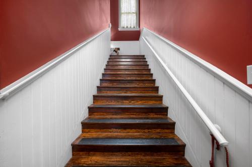 a staircase with wooden floors and red walls at The Vistula Rose B & B in Toledo