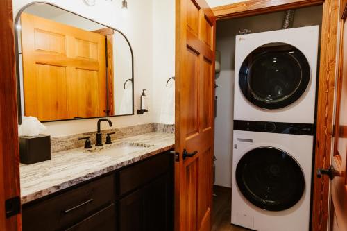 uma casa de banho com um lavatório e uma máquina de lavar roupa em Big Mountain Studio at Switchback Suites em Kalispell