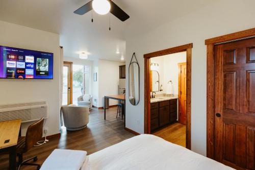 a bedroom with a bed and a desk and a bathroom at Big Mountain Suite Near Logan Health in Kalispell