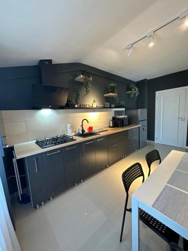 a kitchen with grey cabinets and a table and chairs at Complex Rediu 54 Luxury Apartaments in Iaşi
