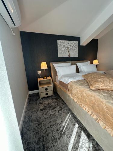 a bedroom with two beds and a table with two lamps at Complex Rediu 54 Luxury Apartaments in Iaşi