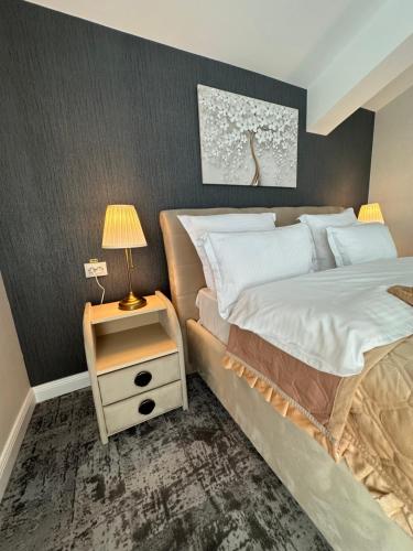 a bedroom with a bed and a table with a lamp at Complex Rediu 54 Luxury Apartaments in Iaşi